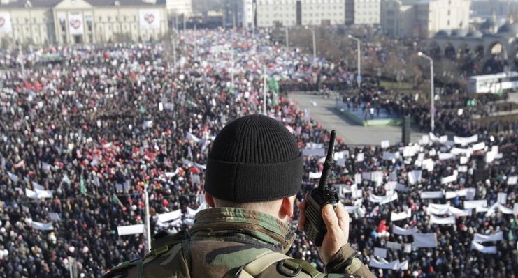 Силовик наблюдает за скоплением людей на площади в Грозном. Фото: REUTERS/Eduard Korniyenko
