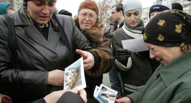Родственники погибших во время атаки на Нальчик рассматривают фотографии. Нальчик. 29 ноября 2005 г. Фото: REUTERS/Viktor Korotayev