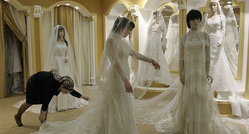 Молодая женщина примеряет свадебное платье в элитном свадебном салоне в Грозном. Фото: REUTERS/Diana Markosian