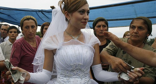 Гости дают деньги невесте во время свадьбы в деревне Мусаим возле Дербента. Фото: REUTERS/Thomas Peter
