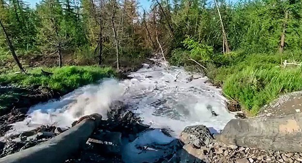 Вода из отстойного пруда вытекает в тундру на предприятии "Норникель". Стоп-кадр видео "Новая Газета"