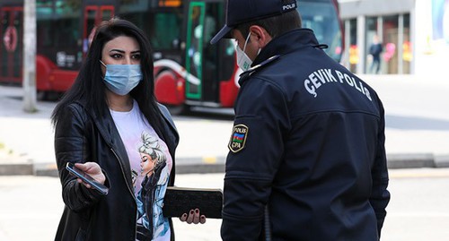 Сотрудник правоохранительных органов проверяет документы у женщины на улице в Баку. Фото Азиза Каримова для "Кавказского узла"