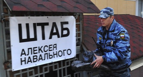 Сотрудник полиции возле таблички "Штаб Алексея Навального". Абстрактная иллюстрация. Фото: REUTERS/Sergei Brovko 