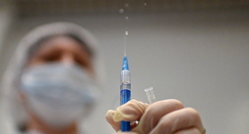 Медицинский работник держит шприц с вакциной против COVID. Фото: REUTERS/Alexey Malgavko