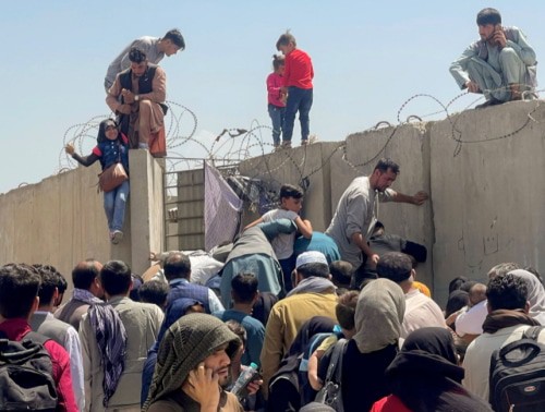 Бегущие от талибов пытаются перебраться через ограду аэропорта в Кабуле, фото REUTERS/Stringer