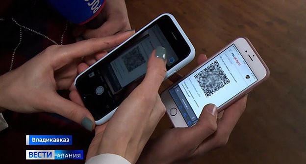 Мобильные телефоны с QR-кодами. Скриншот видео "ГТРК Алания" https://www.youtube.com/watch?time_continue=64&v=4IY4jFwRSiw&feature=emb_logo