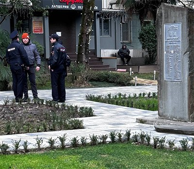 Силовики опрашивают мужчину в Сочи, около Камня памяти жертвам политических репрессий, где расположен мемориал в память о Навальном*. Фотография предоставлена одним из местных активистов