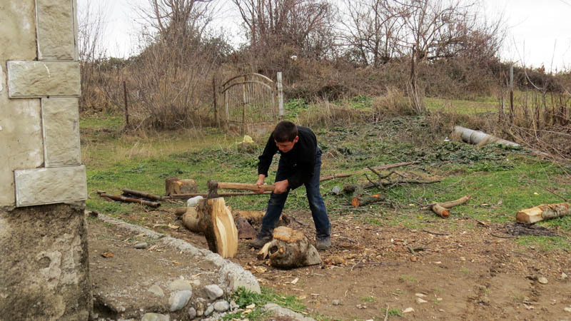 Толик колет дрова для дома.